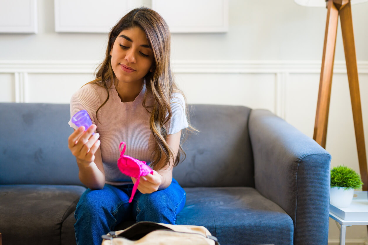 A woman looking at her menstrual cup.
