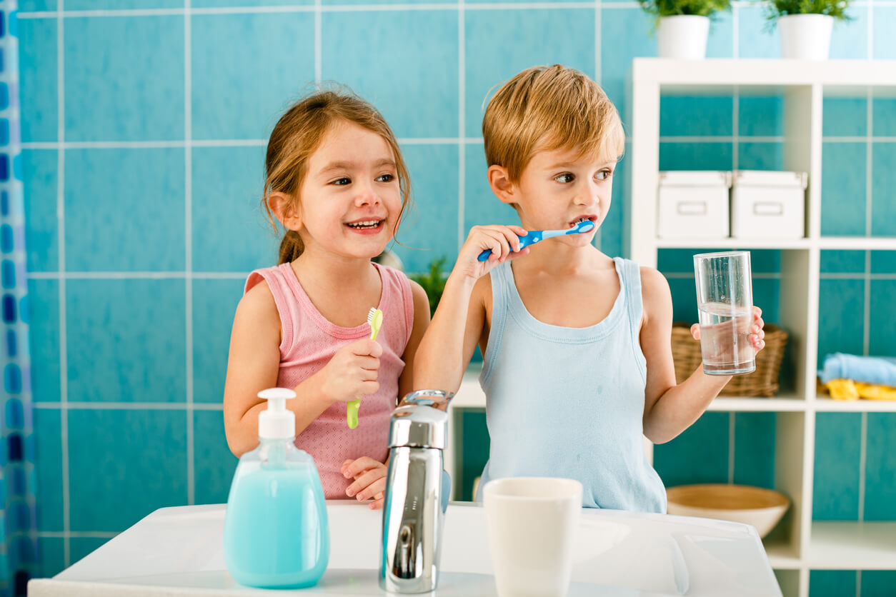 Two young children brushing their teeth.