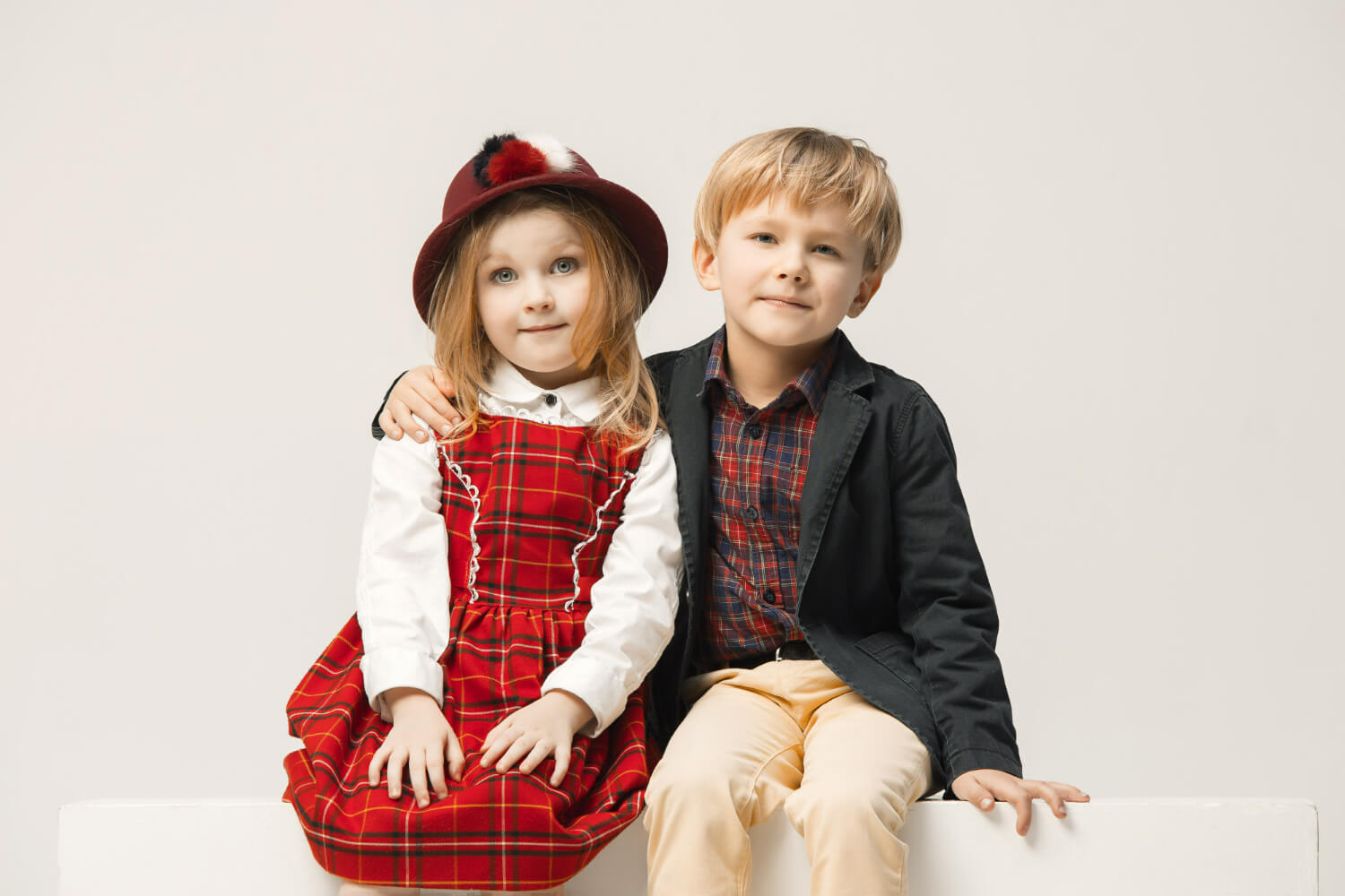 A young boy and girl wearing red plaid.